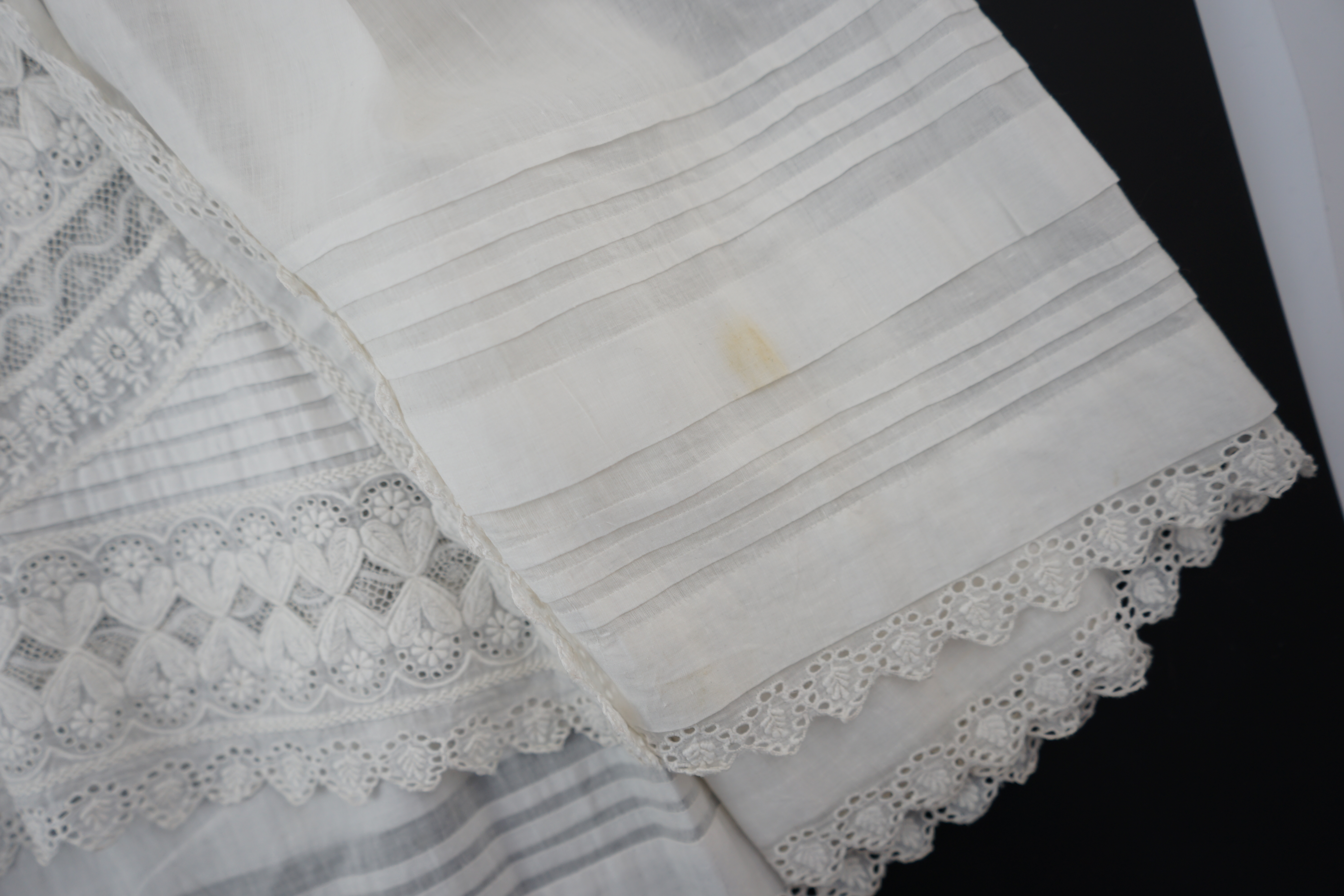 Two unusual 19th century intricately white worked children’s dresses, one hand worked with fine panels of white work, feather stitching and tucking, edged and inserted with hand made Valenciennes lace, the other worked i